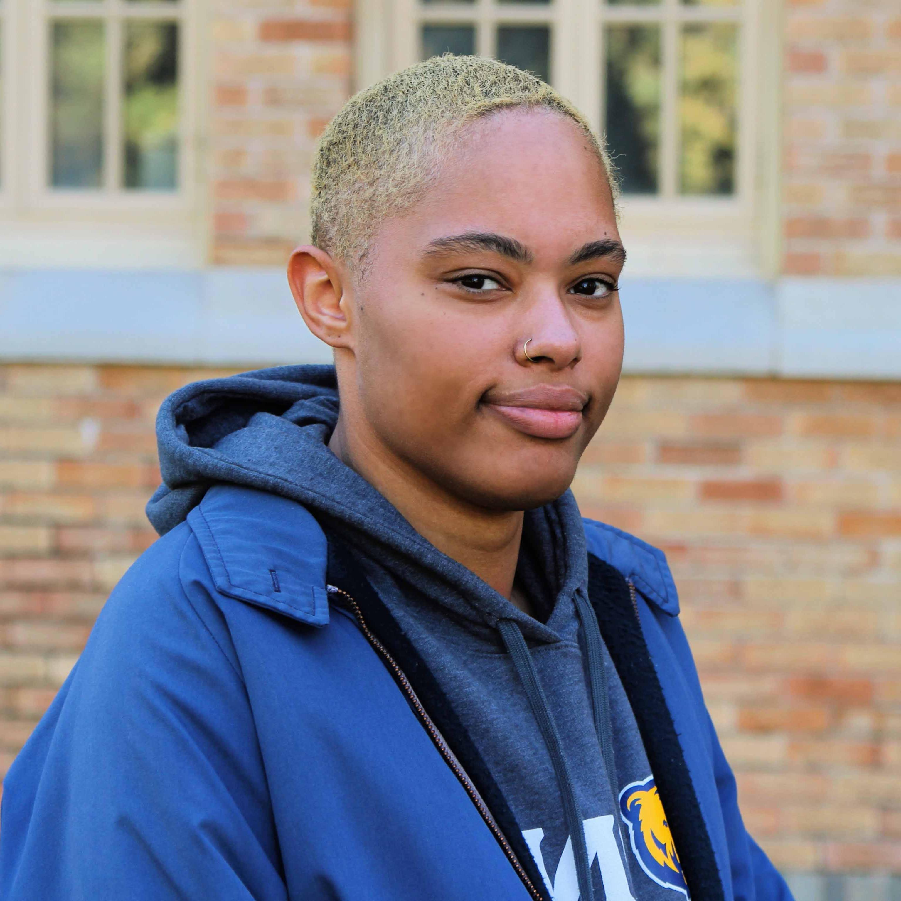 A woman smiles while looking at the camera.