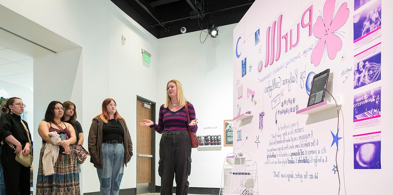 Students standing in front of artwork depicting Purlll magazine.