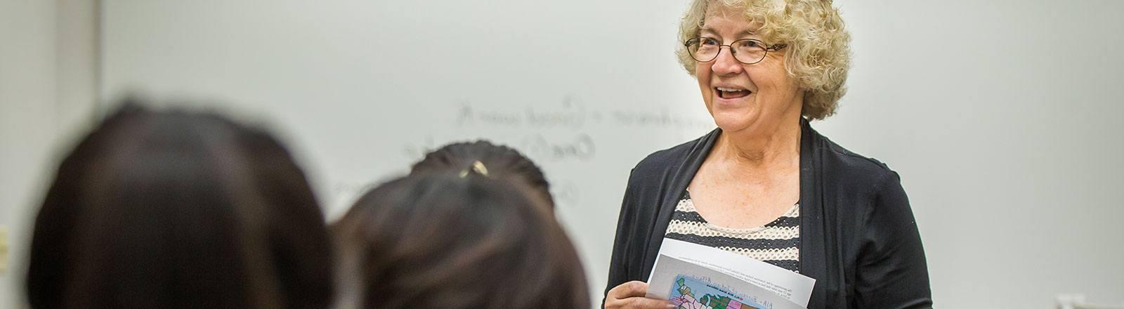 Professor in front of students speaking with paper of United States map